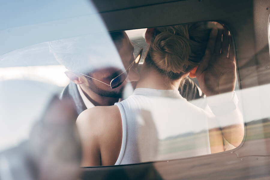 Mężczyzna całujący kobietę w szyję w aucie Mężczyzna całujący kobietę w szyję w aucie