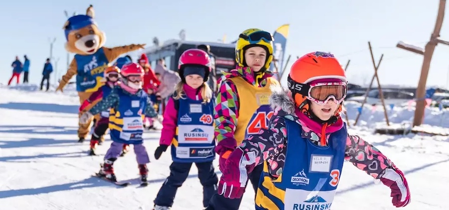 Dzieci jadące na nartach na stoku Dzieci jadące na nartach na stoku